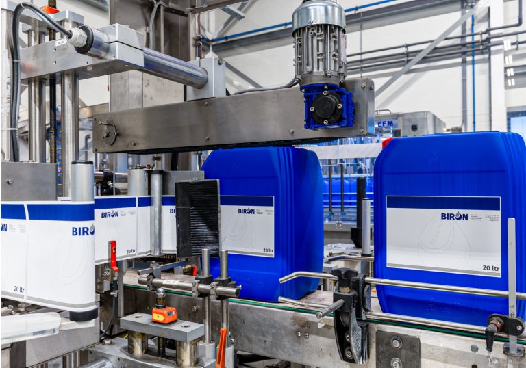 Een productielijn waar vaatjes worden gelabeld